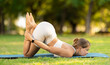 © JackF - Girl fulfill Uttana Shishasana, puppy pose, caterpillar pose, ashtangasana during yoga workout in city park, on green lawn. Concept of balance, relaxation, physical health, longevity