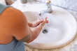 © ADDICTIVE STOCK - Washing hands in a bathroom sink, focusing on hygiene