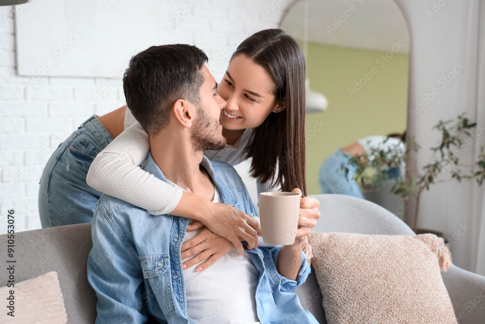 Young woman hugging her beloved boyfriend at home