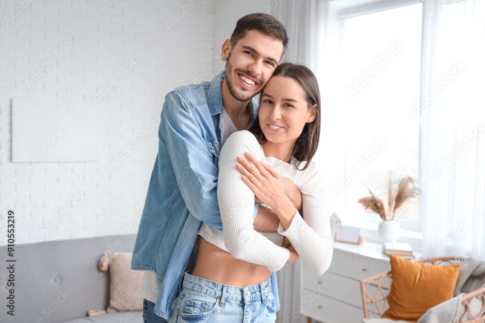 Young man hugging his beloved girlfriend at home