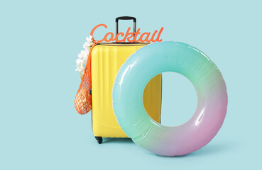 Wall Mural - Packed suitcase, inflatable ring and sign with word COCKTAIL on color background