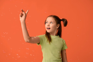 Poster - Cute girl with soap bubbles on orange background