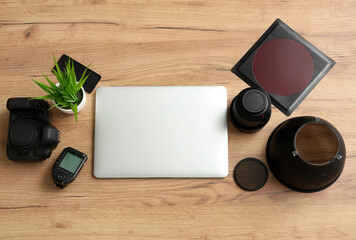 Canvas Print - Composition with modern laptop and professional photographer's equipment on wooden background