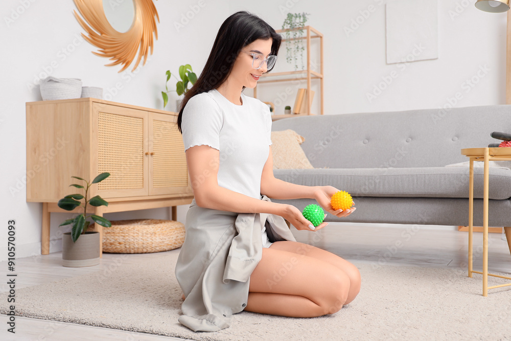 Young woman with massage balls sitting at home
