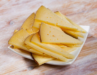 Canvas Print - Sliced ripened semi-hard cheese on wooden table