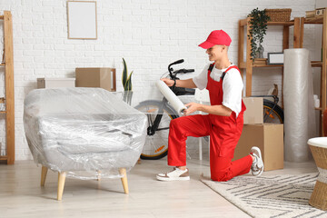 Sticker - Male worker wrapping armchair with stretch film in room