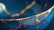 © Y_Malashkevych - Kintsugi, close-up of blue bowl with golden repair lines, Japanese art of golden joinery concept