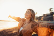 © Daniel - Portrait of one young woman at the beach with openened arms enjoying free time and freedom outdoors. Having fun relaxing and living happy moments..