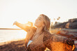 © Daniel - Portrait of one young woman at the beach with openened arms enjoying free time and freedom outdoors. Having fun relaxing and living happy moments..
