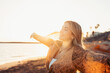 © Daniel - Portrait of one young woman at the beach with openened arms enjoying free time and freedom outdoors. Having fun relaxing and living happy moments..