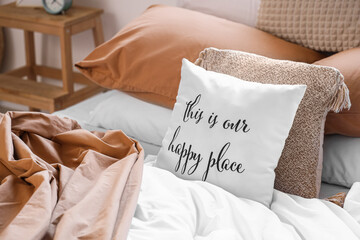 Wall Mural - Big comfortable bed with crumpled linen and pillow with text THIS IS OUR HAPPY PLACE in room. Closeup