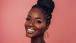 © Surachetsh - Smiling brunette African American woman, with a fashionable model appearance, posing against a studio backdrop of orange and old rose hues.