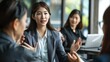 © Preecha - Highly detailed photograph of an Asian woman in business attire giving instructions to her coworkers