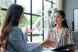 © Phimwilai - Two beautiful Asian businesswomen in conversation Exchange ideas, present analysis of marketing and investment plans. Document assignment accounting business concept online marketing.