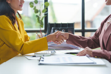 Businesswoman and financial representative shake hands after agreeing on a budget for business expansion and investment. Plans for construction projects Real estate finance concepts.