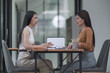 © Songsak C - Two young Asian businesswomen discussed investment project work and planning strategy. Business people talk together on laptop computers at the office.