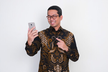 Wall Mural - Adult Asian man looking and pointing his mobile phone with happy expression