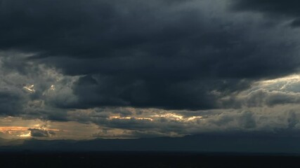 Wall Mural - Dramatic timelapse of orange and blue clouds streaking across a darkening in Nature Environment Dark huge cloud sky black stormy cloud motion big stormy rain sunset sky