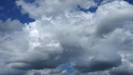 Wall Mural - Time-lapse of Dramatic fluffy white clouds dancing across a vibrant blue sky