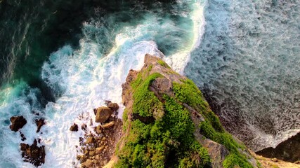 Wall Mural - Top down video of waves crashing in ocean near Uluwatu temple in Bali Indonesia