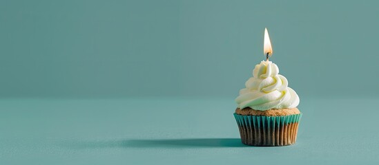 Aufkleber - A tasty cupcake with a lit candle is placed on a soft green backdrop leaving room for a message in this copy space image