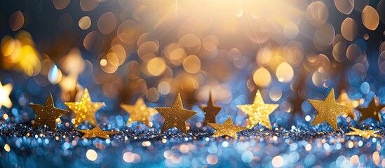 Leinwandbilder - Festive backdrop with a blurred copy space image featuring golden yellow stars scattered on a blue paper background ideal for New Year and Christmas celebrations