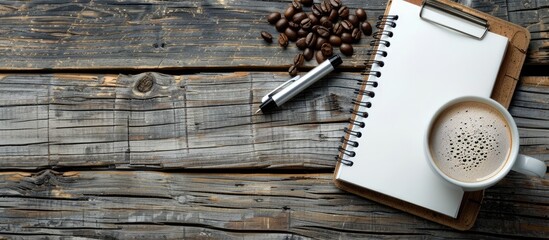 Leinwandbilder - Top view of a notepad pen and coffee on a wooden table in a retro style with a blank space for an image. Creative banner. Copyspace image