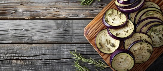 Canvas Print - Eggplant slices arranged on a wooden cutting board placed on a table with copy space image