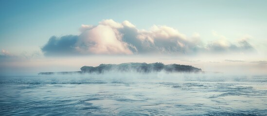 Poster - Island covered in fog on the horizon over the sea with copy space image
