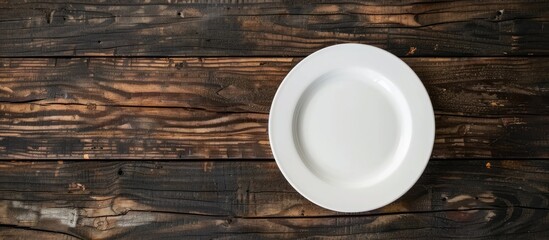Poster - Wooden background showcasing an empty white plate with copy space image