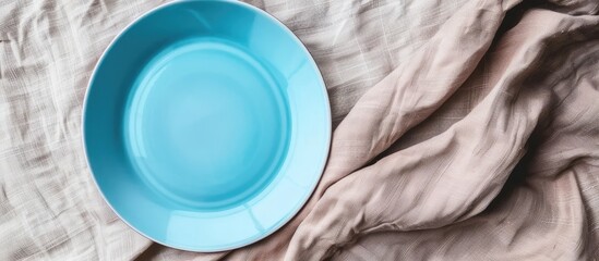 Poster - Top view of an empty blue plate on a tablecloth with a napkin and copy space image for your design