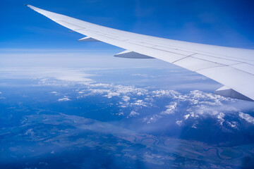 Wall Mural - view from an airplane on a blue sky and white clouds