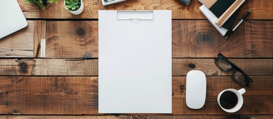 Poster - Minimal flat lay style with a blank paper page on a wooden office desk accompanied by various objects providing a copy space image