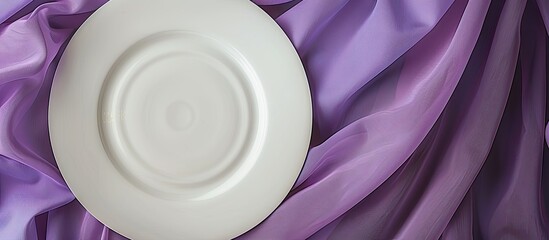 Poster - White dinner plate showcased with a rolled purple table linen creating an elegant setting against a blank canvas with copy space image