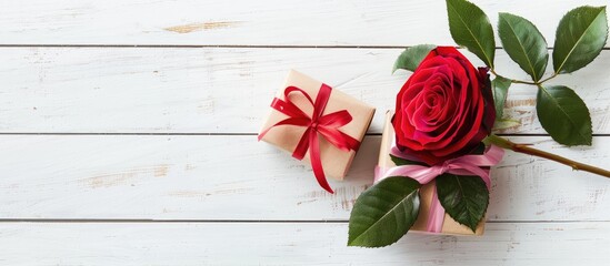 Leinwandbilder - Love and Valentine s concept depicted in an image showing a red and pink rose with a gift box on a white wooden background with copy space image available