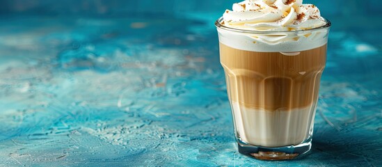 Poster - A glass of coffee with whipped cream on a blue background perfect for a copy space image