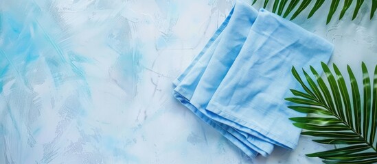 Poster - A folded blue kitchen napkin isolated on a table background ideal for mockups with copy space image Set in a minimalist flat lay style