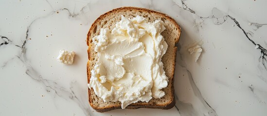 Poster - Top down view of a slice of bread spread with delicious cream cheese on a white marble surface with room for text in the image s background. Creative banner. Copyspace image