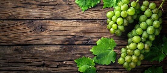 Aufkleber - Fresh green grapes with a bunch and vine leaf displayed on a wooden background in a top view flat lay style with copy space image