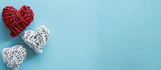 Leinwandbilder - Valentine s Day themed flat lay featuring white rattan hearts with a red heart on a blue background ideal for a greeting card with copy space image