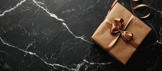 Leinwandbilder - Top view of a gift box placed on a black marble surface with empty space for text or images in the background. Creative banner. Copyspace image