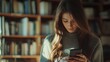 © Alexandr - Woman reading on phone in library