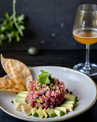 Wall Mural - A sumptuous tuna tartare with avocado, sesame seeds, and a soy-ginger dressing, served with crispy wonton chips