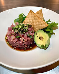 Wall Mural - A sumptuous tuna tartare with avocado, sesame seeds, and a soy-ginger dressing, served with crispy wonton chips