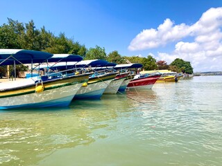 A row of boats on a beach harbor on a summer day, holiday on tropical island