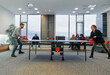 © .shock - Business colleagues take a break from work to enjoy a game of table tennis, fostering teamwork and camaraderie in the workplace