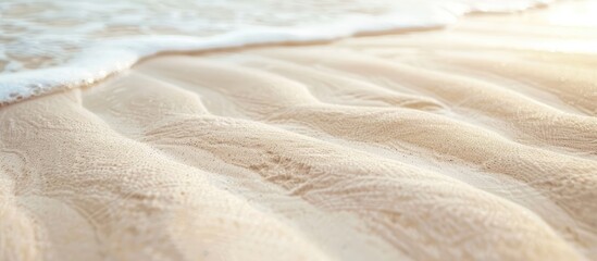 Wall Mural - Close up of a textured white sandy beach with a wavy pattern natural grains clean rippled surface light yellow dunes on a tropical sea backdrop with copy space image