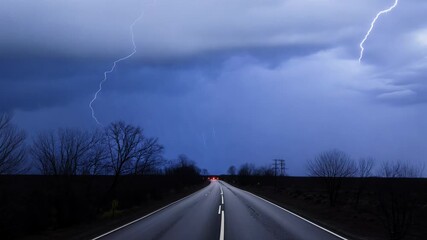Wall Mural - a lightning bolt strikes a road in the middle of a storm. the sky is dark and the lightning is brigh