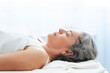 © Westend61 - Mature woman with acupuncture needles over forehead lying on massage table
