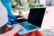 © Westend61 - Businesswoman scrolling on laptop sitting at office park